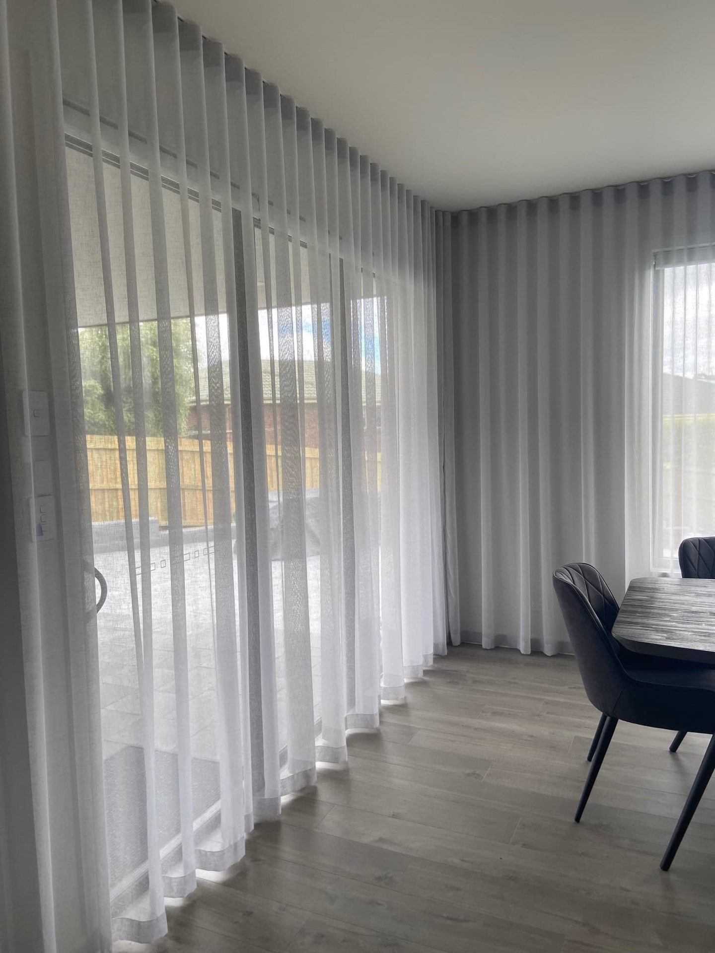 Sheer S-Fold curtains on a ceiling mounted track running wall to wall