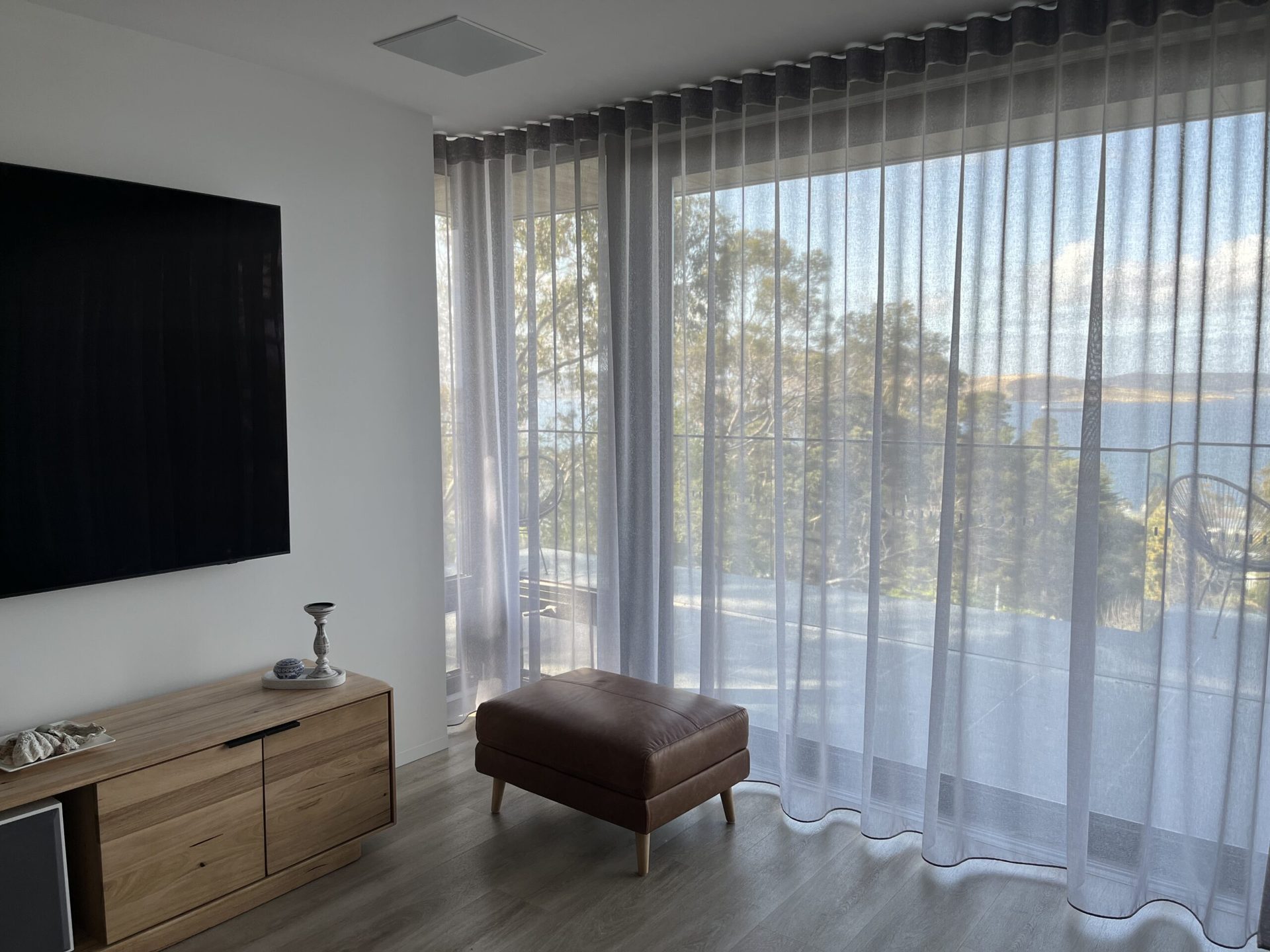 Sheer curtains in a bedroom with a timber floor