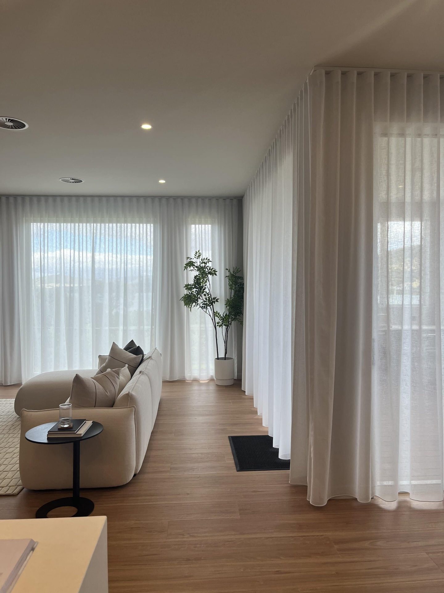 Sheer curtains along a hallway beside a dining setting