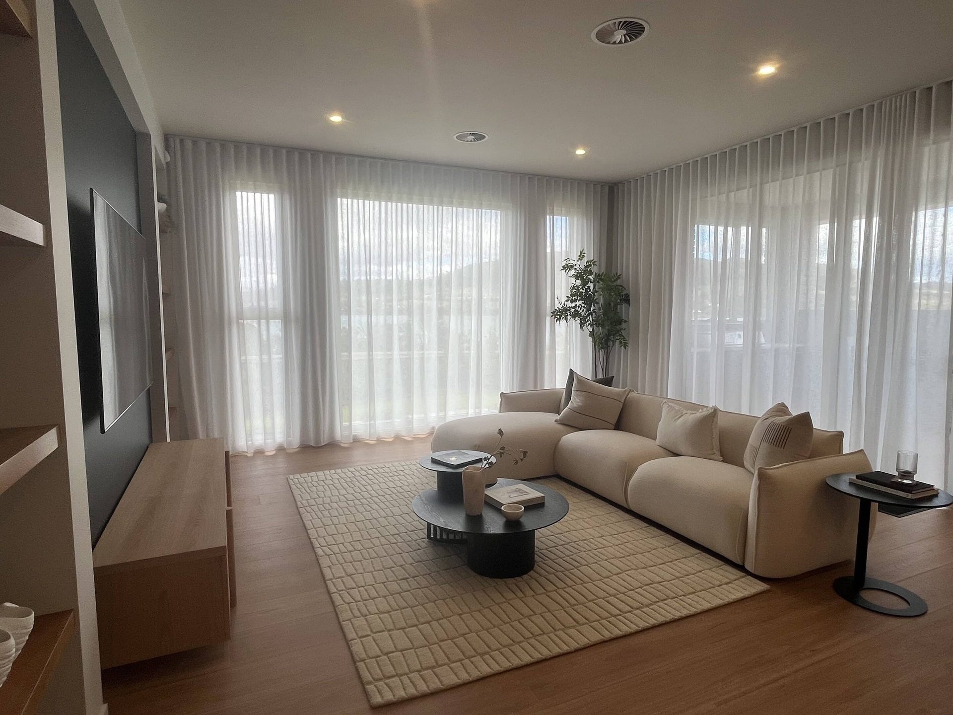 Sheer curtains behind a lounge suite in an open living room