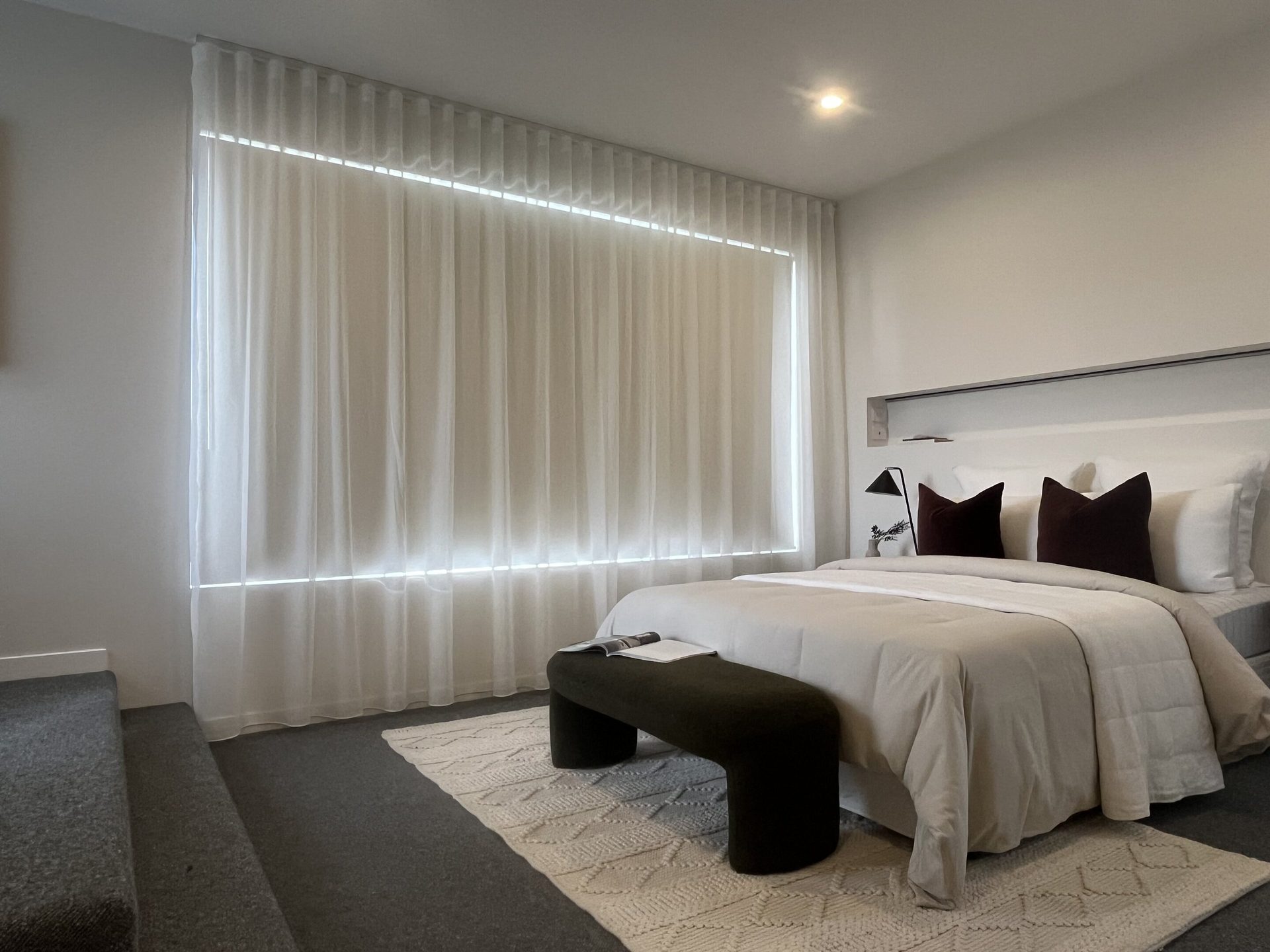 Bedroom with layered sheers and a blockout roller blind
