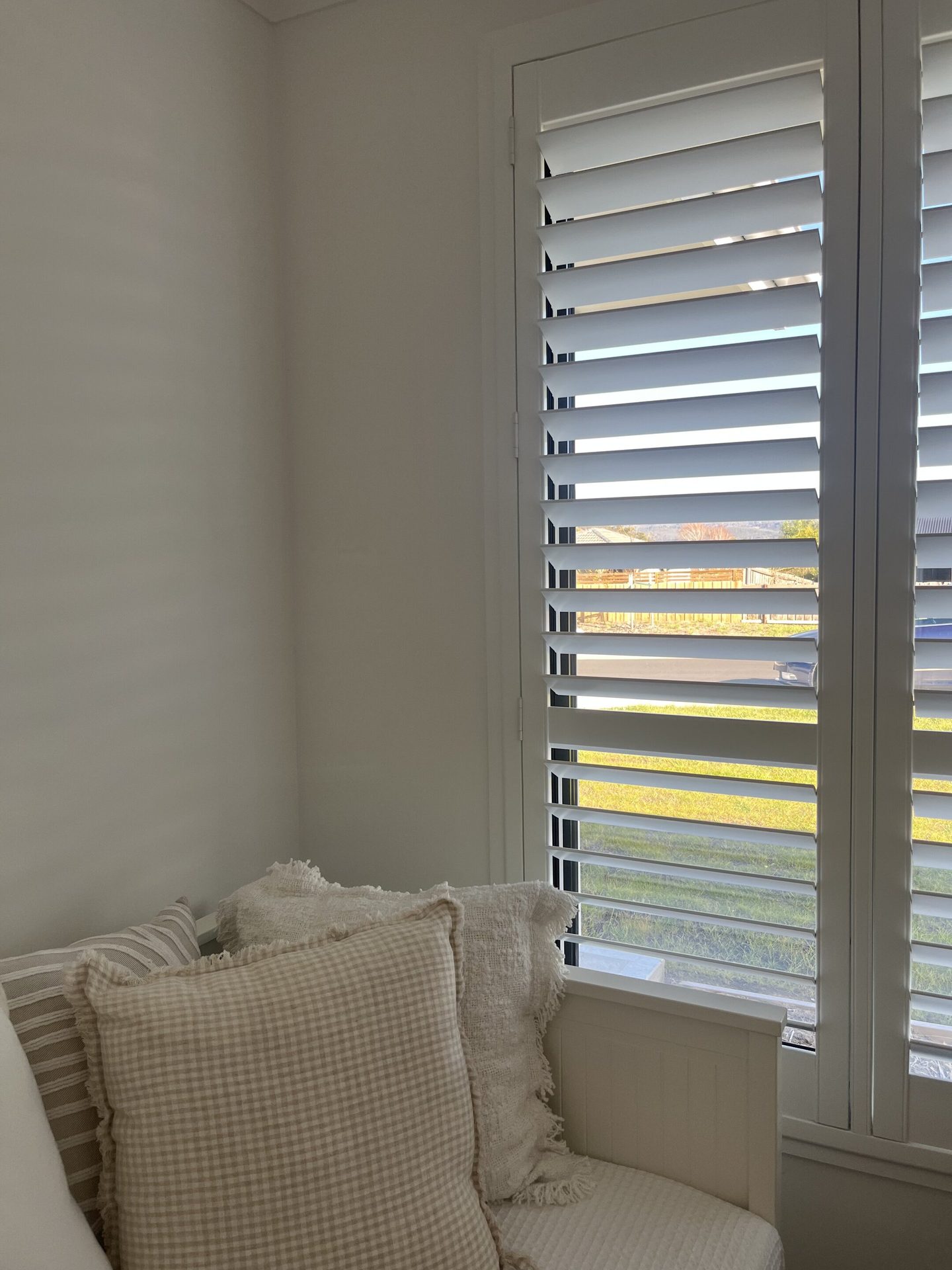 Bedroom with sheer curtains drawn across the corner windows
